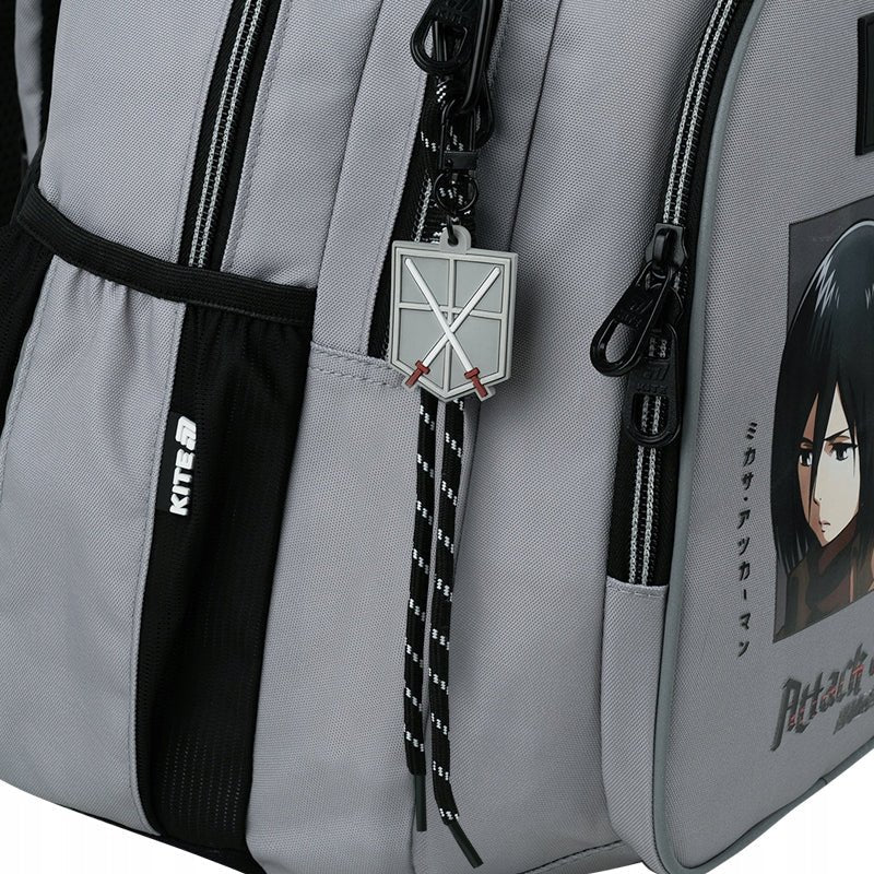 Zbliżenie na unikalną zawieszkę z motywem Attack on Titan przy suwaku.