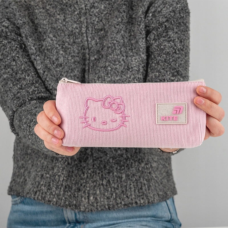 Dziewczynka trzymająca różowy piórnik dla dziewczynki z licencją Hello Kitty.