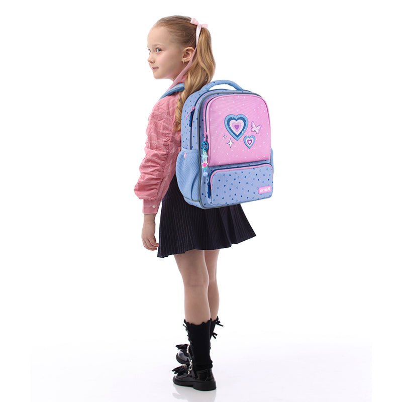 Lekki plecak Kite Kids K25-559XS-1 z licznymi kieszonkami, trzymany przez dziecko