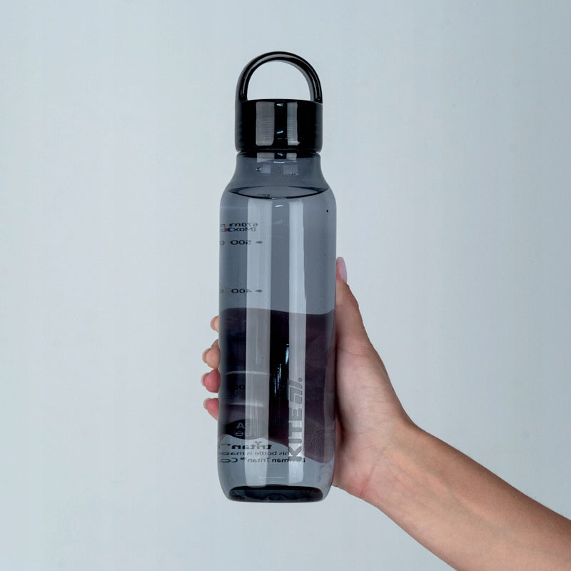 Ręka trzymająca szarą butelkę tritanową Kite 670 ml z pętlą