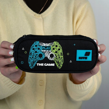 Zamknięty piórnik z motywem Game trzymany przez ucznia.